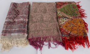 A 19th century fine silk shawl with a fringe; a wool shawl with red fringing; and a printed shawl (