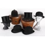 Two black silk top hats in leather hat boxes, both with a circumference of 22in; together with three