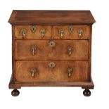 A Queen Anne walnut and featherbanded chest of drawers , circa 1710  A Queen Anne walnut and