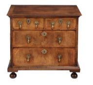 A Queen Anne walnut and featherbanded chest of drawers , circa 1710  A Queen Anne walnut and