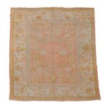 An Ushak carpet, the pale pink field decorated with abstract foliage and...  An Ushak carpet,