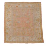 An Ushak carpet, the pale pink field decorated with abstract foliage and...  An Ushak carpet,