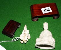 A Japanese netsuke and a small Blanc de chine figure, both on scrolled wooden stands