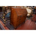 A George III mahogany bureau, circa 1800, with a fitted interior and four long drawers on bracket