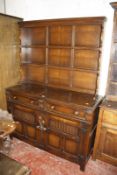 A 19th Century style oak dresser with a plate rack over a base of drawers and cupboards.