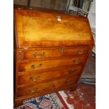 A Georgian style yew wood bureau with a fitted interior.