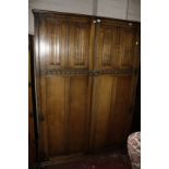 Two oak linen fold panelled wardrobes and a headboard.