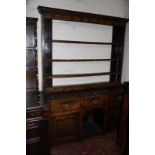 A George III oak high dresser with plate rack and three frieze drawers and two cupboards flanking