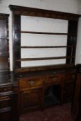 A George III oak high dresser with plate rack and three frieze drawers and two cupboards flanking