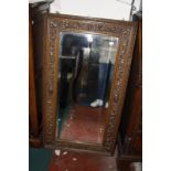 A carved oak framed wall mirror and an Edwardian oval mirror