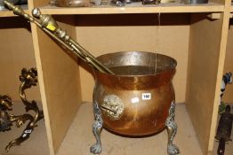 A copper and brass cauldron shaped coal box, three brass fireirons, a trivet, a resin figure of an