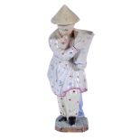 A Hochst Damm faience figure of a Chinese boy  , late 18th Century,  holding a flower vase, wearing