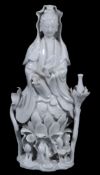 A Dehua figure of Guanyin,   18th century,  holding a scroll and seated on a lotus base, 24.5cm