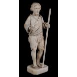 A Dieppe ivory statuette of a beggar,   19th century,  holding a staff,  10cm high