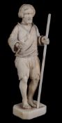 A Dieppe ivory statuette of a beggar,   19th century,  holding a staff,  10cm high