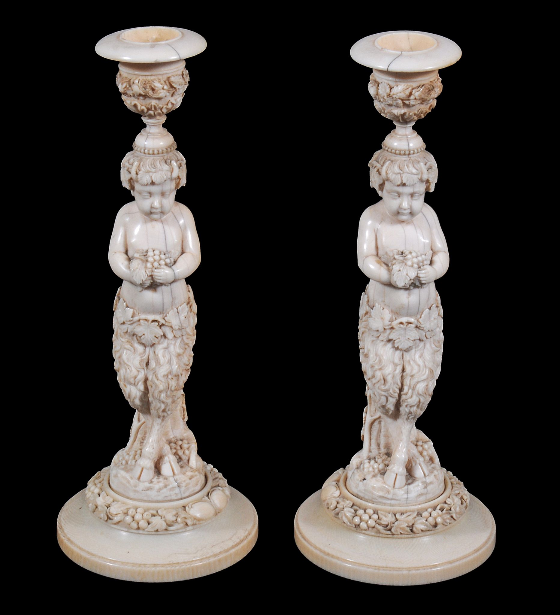 A pair of Continental sculpted ivory figural candlesticks,   mid 19th century,  the capitals above