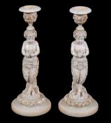 A pair of Continental sculpted ivory figural candlesticks,   mid 19th century,  the capitals above