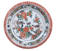 A famille verte plate  , Qing Dynasty, Kangxi (1662-1722),  of circular form with `piecrust' rim,