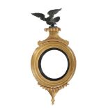 A Regency giltwood convex mirror  , circa 1815, surmounted by an eagle 94cm high, 46cm wide