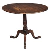 A George III oak tripod table,   the circular tilt top on turned stem with splayed legs and pad