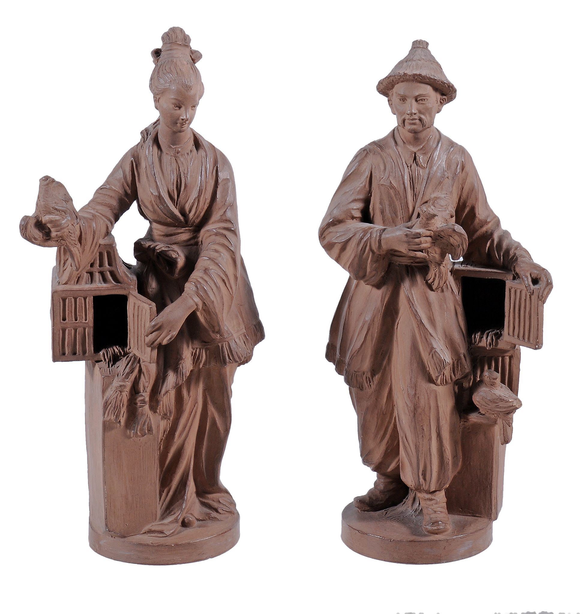A pair of chinoiserie terracotta figures,   20th century,  a man and a woman standing beside bird