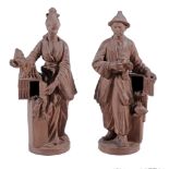 A pair of chinoiserie terracotta figures,   20th century,  a man and a woman standing beside bird