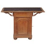 A Gothic Revival oak pedestal writing table  , circa 1880, the tooled leather inset top above a