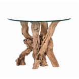 A glass top dining table,   of recent manufacture, the base of natural tree stems, 72.5cm high,