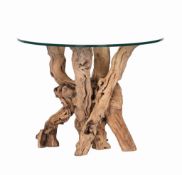 A glass top dining table,   of recent manufacture, the base of natural tree stems, 72.5cm high,