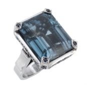 A blue topaz and sapphire ring, the rectangular shaped blue topaz claw set...  A blue topaz and