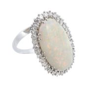 An opal and diamond cluster ring, the oval shaped opal claw set within a...  An opal and diamond