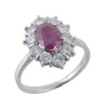 A ruby and diamond cluster ring, the central oval shaped ruby claw set...  A ruby and diamond