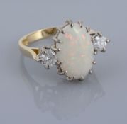 An 18 carat gold opal and diamond ring, the central oval shaped opal claw...  An 18 carat gold