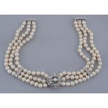 A three strand cultured pearl necklace, the choker composed of uniform...  A three strand cultured