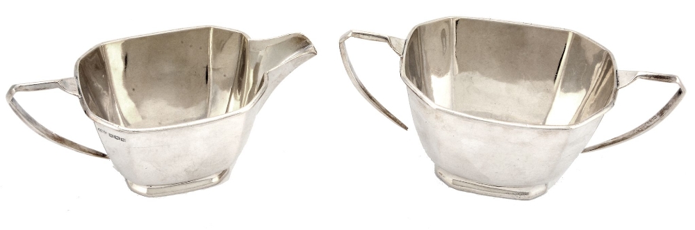 A silver facetted oblong sugar basin and a cream jug by George Wish  A silver facetted oblong