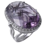 An amethyst and diamond ring, the oval shaped amethyst claw set within a...  An amethyst and diamond