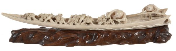 An Ivory Okimono of a Boar's Tooth Boat, the long sleek vessel being steered...  An Ivory Okimono of