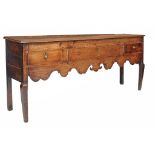 An oak dresser base , early 19th century, the plank top above three short...  An oak dresser base  ,