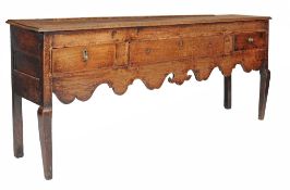 An oak dresser base , early 19th century, the plank top above three short...  An oak dresser base  ,