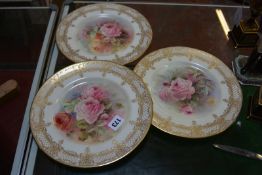 Three Royal Doulton cabinet plates, painted with roses and signed by C. Hart, within an elaborate