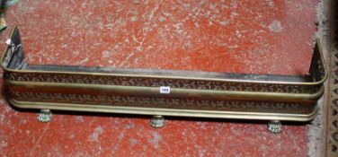 A Victorian pierced brass fender with paw feet 113cm length