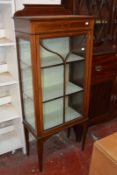 An Edwardian mahogany small display cabinet, the astragal glazed door enclosing shelves 152cm