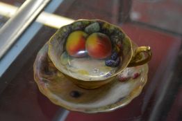 A Royal Worcester teacup and a saucer, painted with Autumnal fruit and signed by W. H. Austin and T.