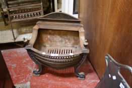 A cast iron firegrate in George III style with arched back on scrolled supports