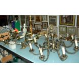A 20th Century brass eight light electrolier, a set of four brass twin light wall appliqués, a