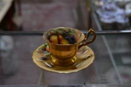 A Royal Worcester coffee cup and saucer, painted with Autumnal fruit and signed by W.Hale, date code