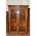 A Victorian walnut wardrobe, with twin arch moulded doors enclosing hanging space 211cm high,