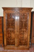 A Victorian walnut wardrobe, with twin arch moulded doors enclosing hanging space 211cm high,