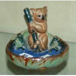 A Royal Doulton Lambeth stoneware ashtray, modelled as a koala bear to a tree branch, impressed