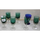 A set of six green glass drinking glasses on clear stems and a blue glass drinking glass -7